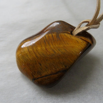 Tiger's eye, drilled stone on leather No. 11